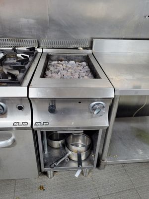 deux cuisinières dans la cuisine, sur lesquelles sont posées des casseroles et des poêles
