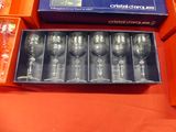 six empty wine glasses in a box on a table