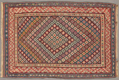 un tapis ancien orné d'un motif en losanges sur fond rouge
