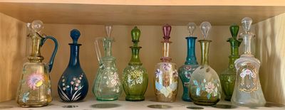 many different colored glass vases on a shelf