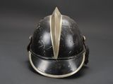 an old black helmet with a gold leaf on the top