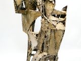 une sculpture représentant un homme assis sur une chaise
