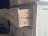 a white dresser with drawers and a tv in the background