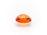 a close up of an orange sapphire stone on a white background