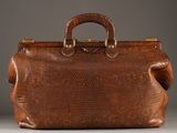 an image of a brown snake skin bag on a gray surface