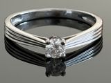 a close up of a diamond ring on a black surface