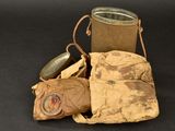 an old bag and a metal container on a black surface