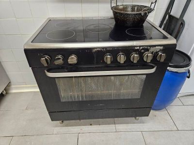 une cuisinière sur laquelle est posée une marmite dans une cuisine