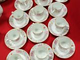 a lot of cups and saucers on a red table