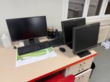 un bureau sur lequel sont posés deux écrans d'ordinateur et un clavier
