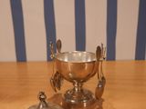 a silver bowl and a silver plate on a wooden table