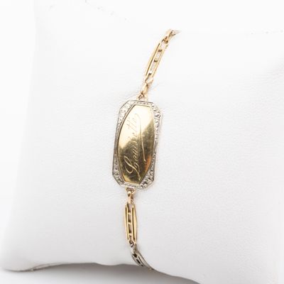 gros plan d'un bracelet en or sur un oreiller blanc