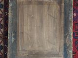 painting of a wooden frame on a red and blue rug