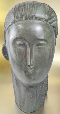 sculpture of a woman ' s head on a table in front of a yellow background