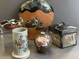 trois vases et une boîte posés sur une table