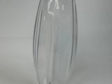 a clear glass vase with a black lid on a white table