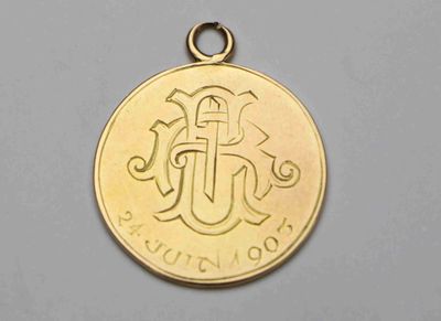 un gros plan d'une pièce d'or sur laquelle figure la lettre j