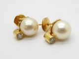 une paire de boucles d'oreilles en perles et diamants sur fond blanc