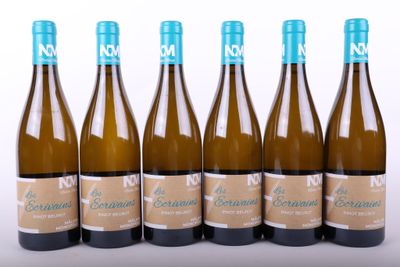 six bottles of wine are lined up in a row on a white surface