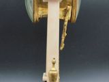 a white and gold clock on a stand on a table
