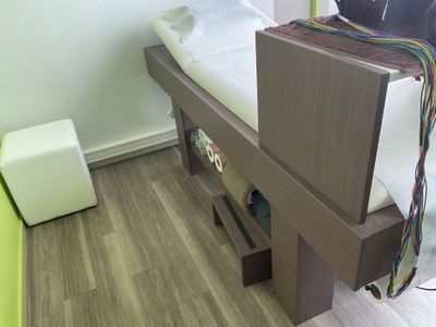 un lit avec un cadre en bois recouvert d'un drap blanc