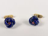 a pair of blue and gold cufflinks on a white background