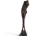 une statue en bronze représentant une femme tenant sa tête entre ses mains