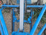 un gros plan d'un tracteur bleu auquel est attachée une chaîne