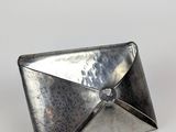 une enveloppe en métal argenté ornée d'un diamant à l'intérieur