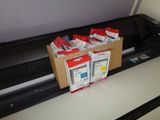 boxes of ink sitting on top of a printer next to a printer