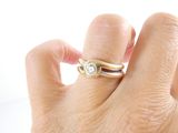a woman ' s hand holding a ring with a diamond on it