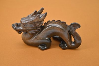 une statue représentant un dragon assis sur une table