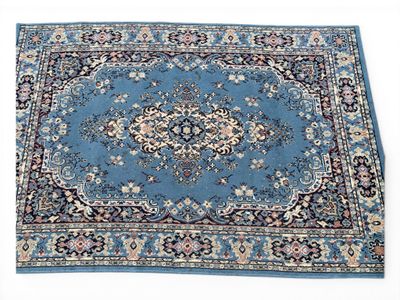un gros plan d'un tapis bleu posé sur une surface blanche