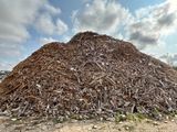 a large pile of wood sitting on the side of the road