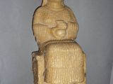 une statue représentant une femme assise sur un rocher