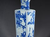 un vase bleu et blanc posé sur un support en bois