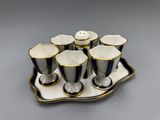 un plateau sur lequel se trouvent six tasses et une soucoupe