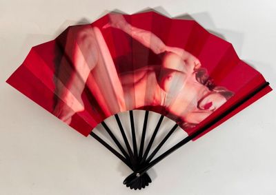 a red fan with a picture of a woman on it