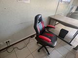 a desk with a computer and a chair in a room