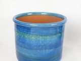 a blue pot with a brown bottom sitting on a white surface