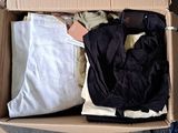 a cardboard box filled with clothes and a cell phone