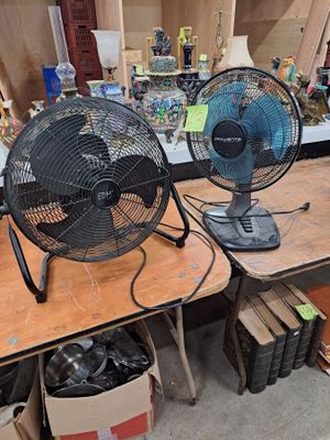 deux ventilateurs posés sur une table dans une pièce