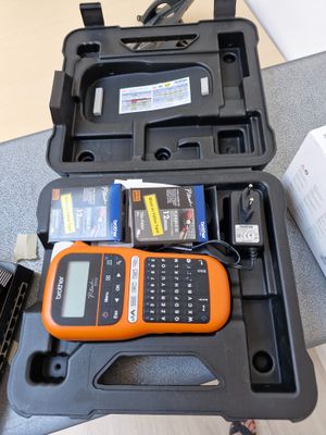 un téléphone portable orange et noir dans un étui, posé sur une table