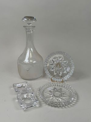 a glass bottle, a glass plate, and a glass plate on a table