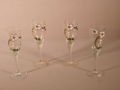 quatre verres à vin décorés de fleurs, posés sur une table