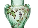 un vase vert sur lequel sont peints des fleurs et des feuilles