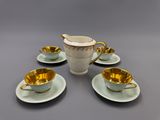 a set of four cups and saucers with gold rims