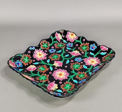 une image représentant un bol noir orné de fleurs colorées
