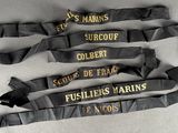 several black and gold ribbons with names on them on a white surface