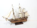 a small model of a sailboat on a wooden stand